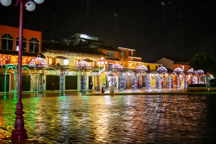 The arcades of the square with lit arches in the colors of the flag