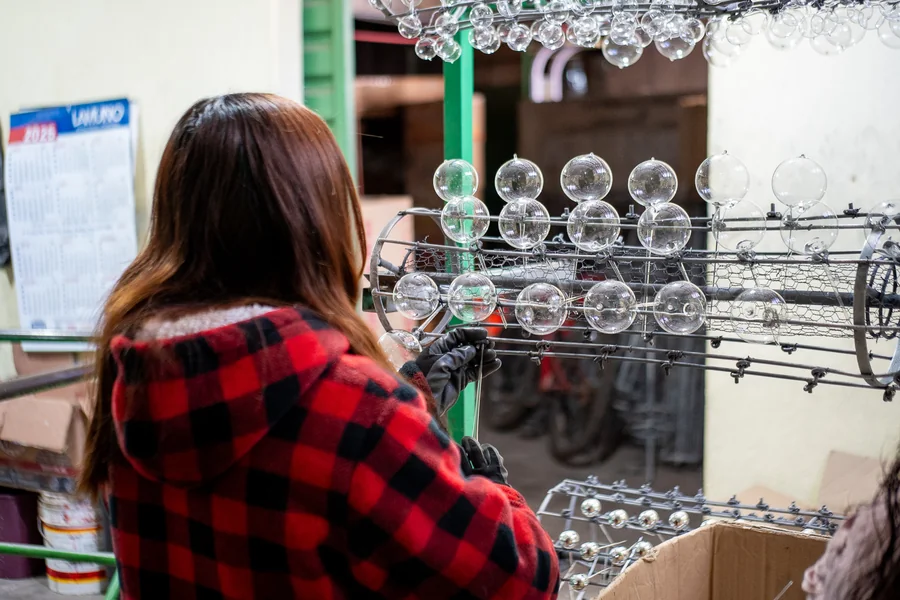 Una artesana trabaja las esferas en el taller: el oficio se vuelve herencia familiar