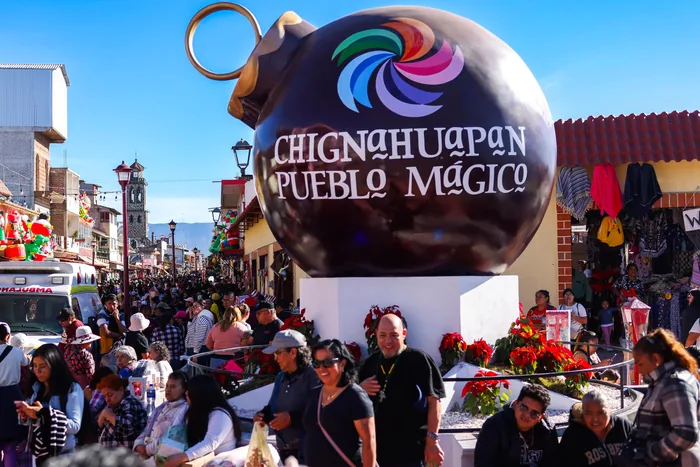 La Esfera Monumental con el letrero Chignahuapan Pueblo Mágico, rodeada de visitantes bajo el cielo azul