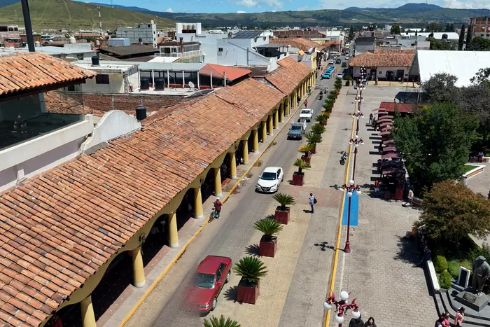 Los portales del centro de Chignahuapan desde el aire: tejados de teja roja sobre los arcos y la calle junto a la plaza.