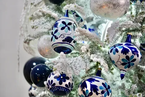 Hand-painted blue and white ornaments on a snowy tree