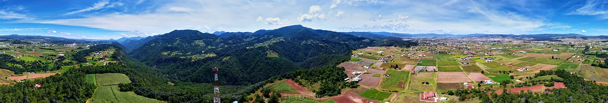 Panorámica del valle de Chignahuapan con campos de cultivo, bosque y las montañas de la sierra al fondo