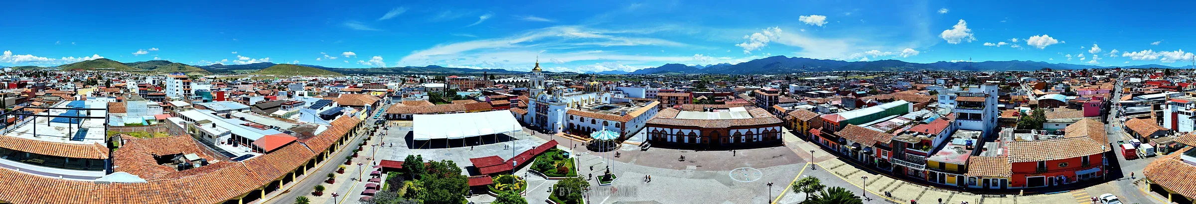 The main square of Chignahuapan and its arcades seen from the sky in the 360 tour, with the mountains behind