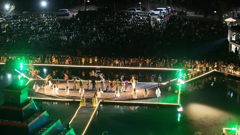 La función desde el dron: el escenario sobre la laguna, la pirámide encendida y la tribuna llena de público