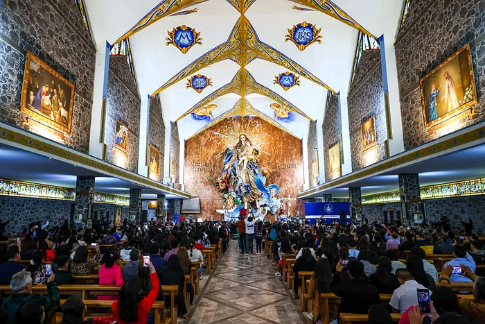 The Basilica of Chignahuapan full of worshippers, with the full image of the Virgin of the Immaculate Conception at the far end of the church