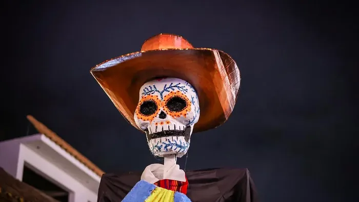 Una calavera gigante de catrín, con sombrero y sarape de colores, recorre de noche las calles del pueblo