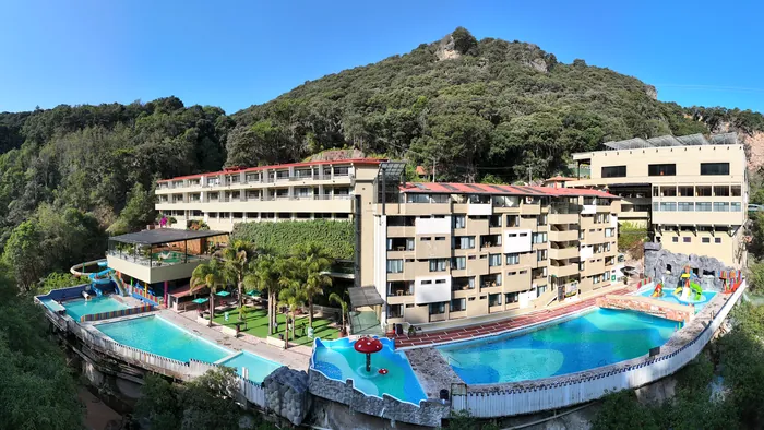 The hot springs resort with its pools in the ravine at the foot of the hill, seen from the air