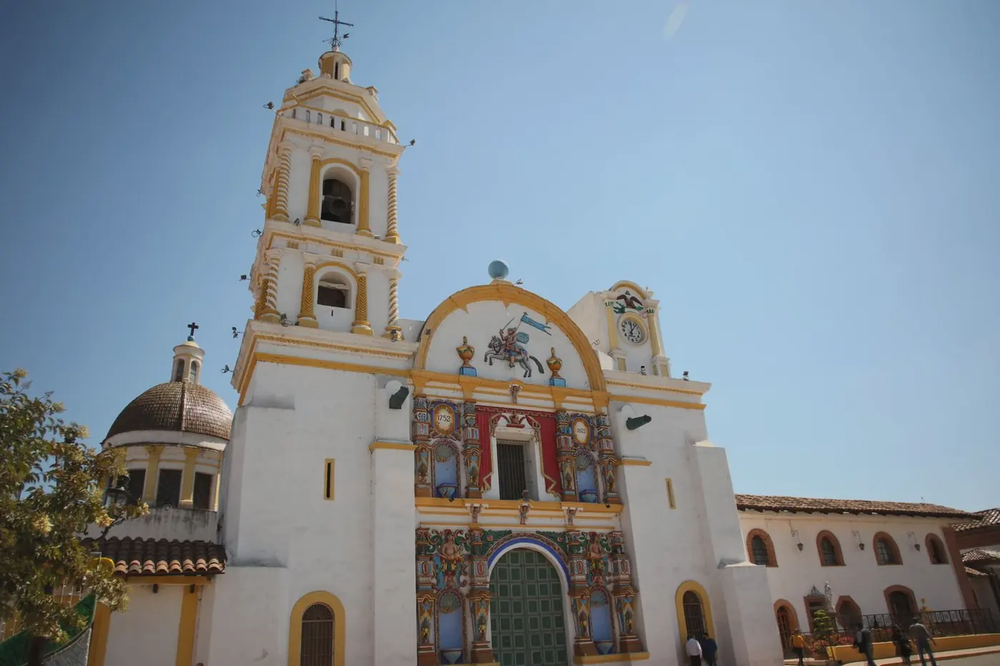 Fachada de la Parroquia de Santiago Apóstol, con su torre y los relieves policromados del barroco indígena, frente a la plaza de Chignahuapan