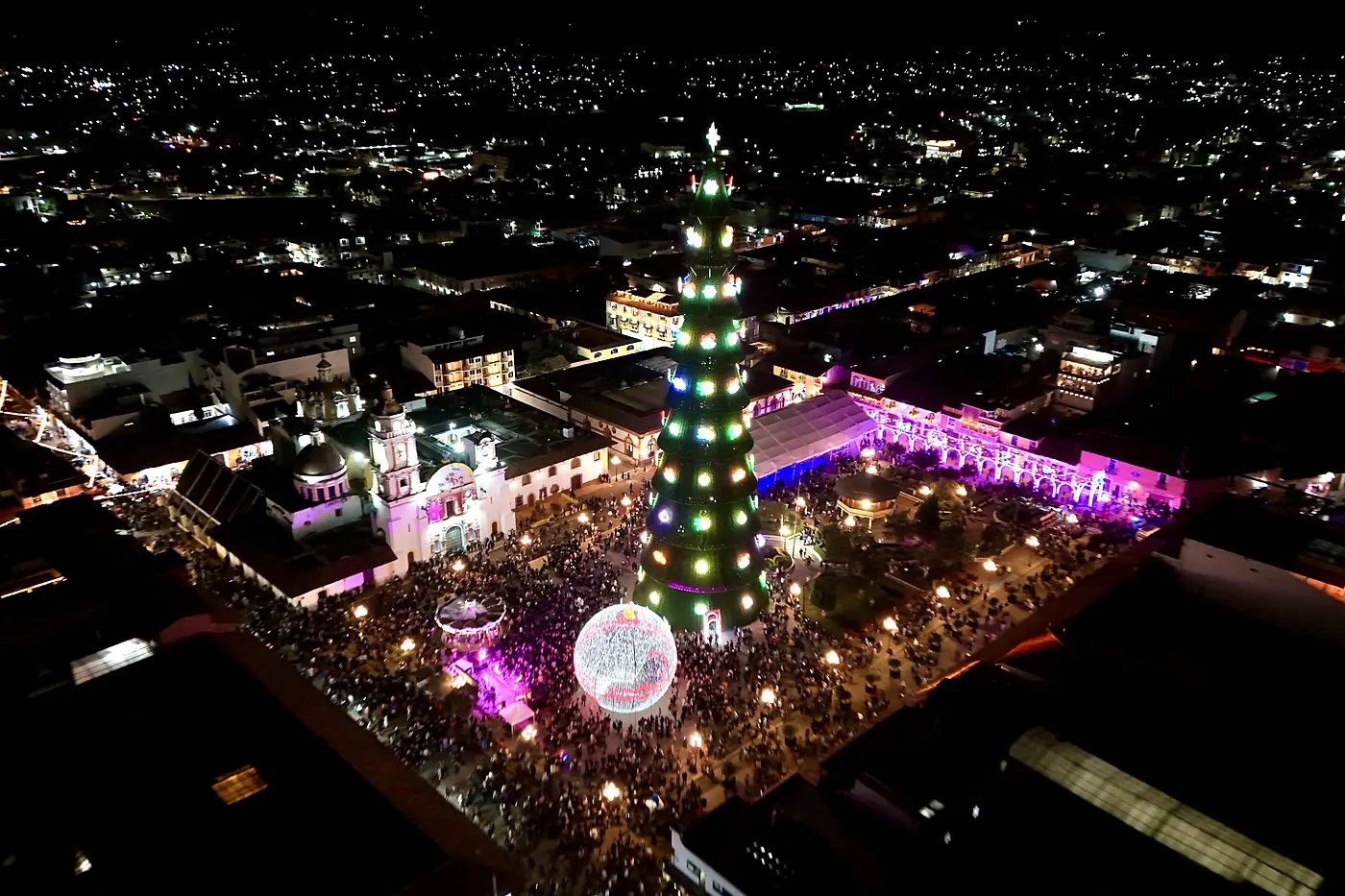 El árbol y la esfera monumentales encendidos en la plaza de Chignahuapan, vistos desde el aire de noche