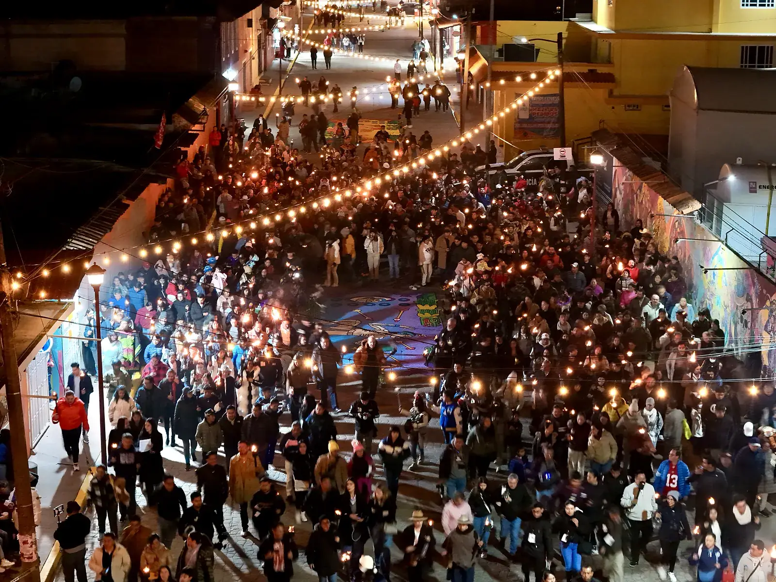 Cientos de vecinos caminan de noche con sus antorchas encendidas por la calle rumbo a la laguna