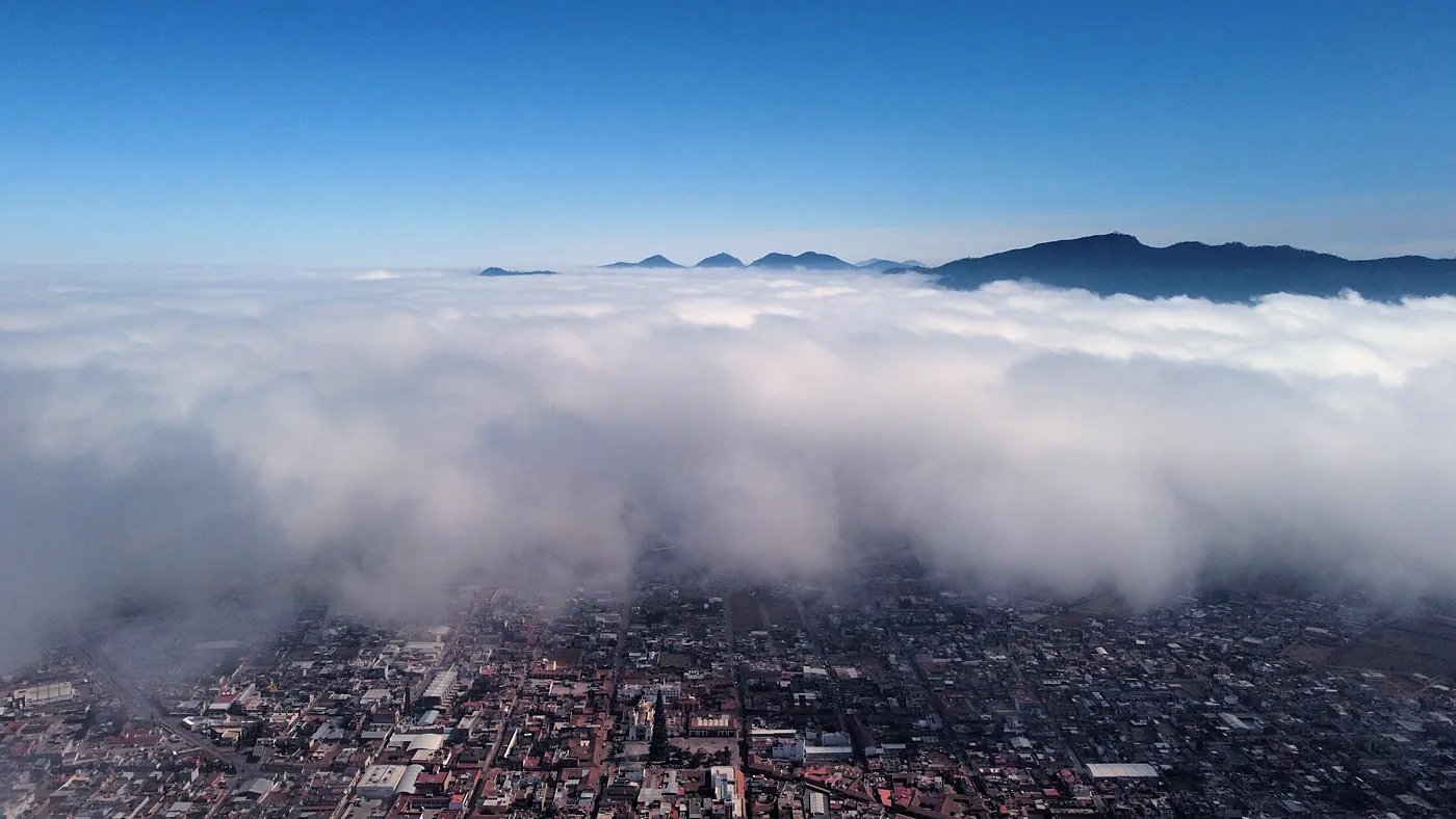 Mar de nubes sobre Chignahuapan en una mañana fría, con las cumbres de la sierra asomando bajo el cielo azul