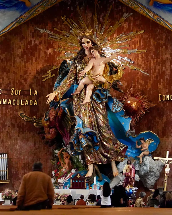 La Virgen de la Inmaculada Concepción, de más de 12 metros y tallada en madera, con el Niño en brazos y el manto azul, en el altar de la Basílica.