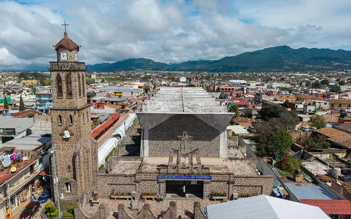 La Basílica de la Inmaculada Concepción desde el dron, de frente: la torre de piedra, la entrada con su letrero y el techo en zigzag